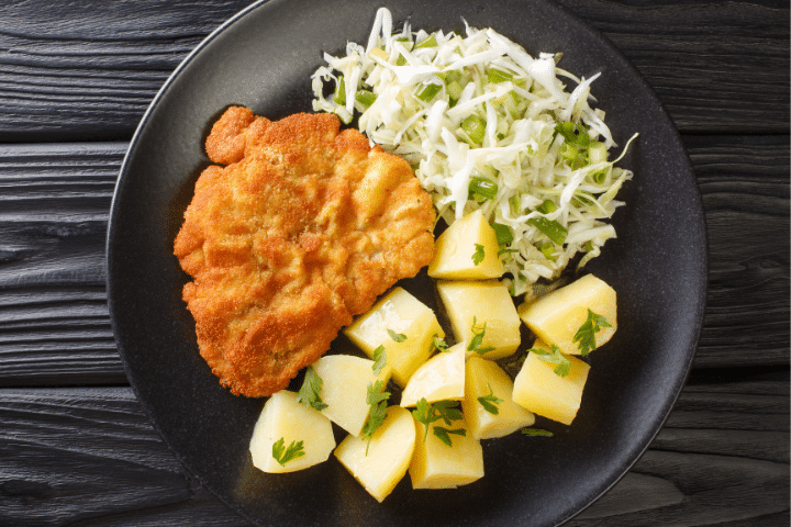 kotlet schabowy, escalopes panées à la polonaise avec des pommes de terre et de la salade de chou (surówka)