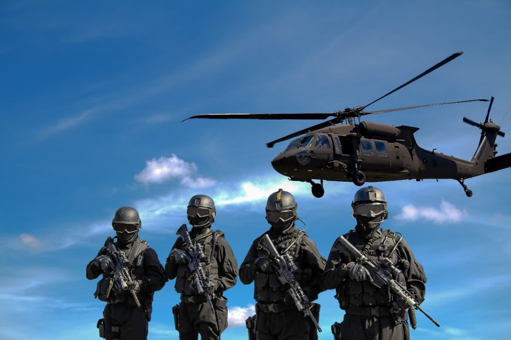 4 soldats de l'armée, et un hélicoptère de l'armée au dessus d'eux. 