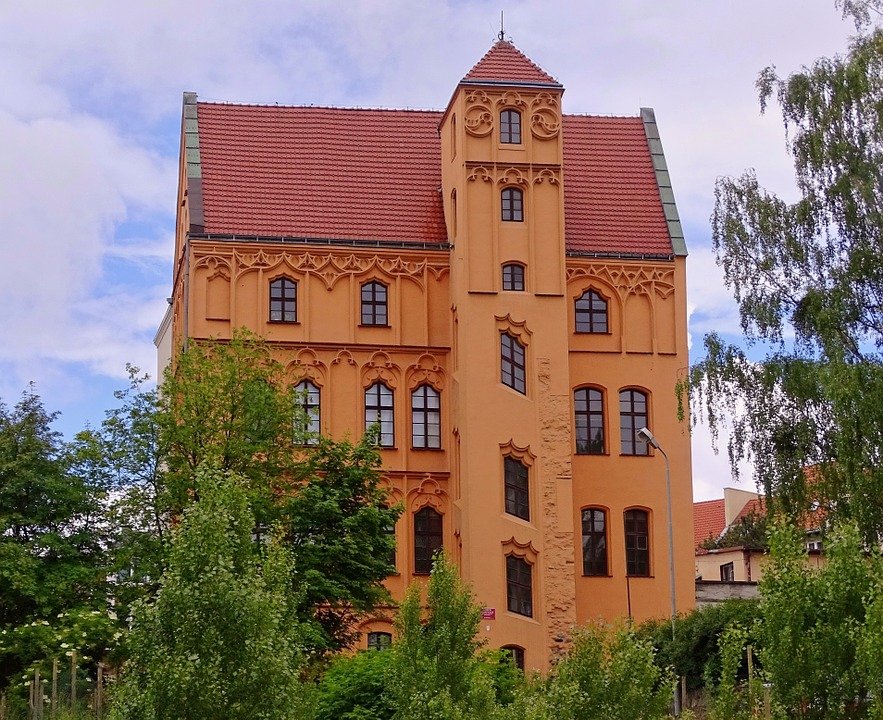 L'immeuble des Loitz domine le quartier de sa hauteur, avec ses murs oranges et son toit rouge très incliné. Le haut des fenêtres est joliment décoré. L'immeuble comprend une tour dont les trois fenêtres les plus basses sont obliques.